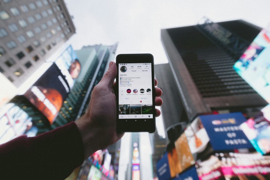 photo of person holding phone with Instagram open in the city